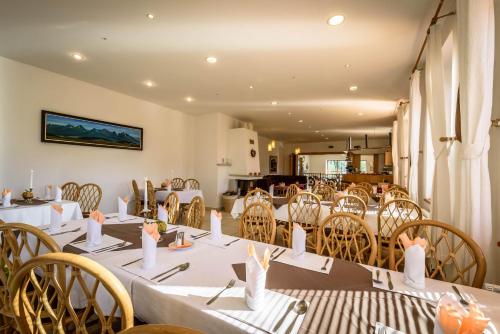 a dining room with white tables and chairs at Hotel Villa Siesta in Vysoke Tatry - Novy Smokovec