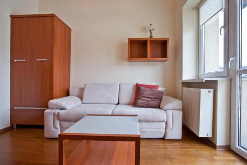 a living room with a couch and a table at Apartamenty Sun & Snow Krynica Zdrój Pułaskiego in Krynica Zdrój