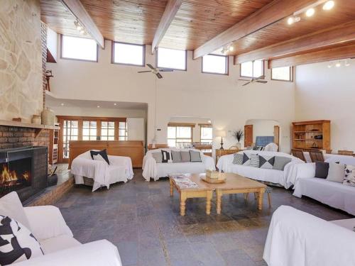 una gran sala de estar con muebles blancos y chimenea. en Steeles Island Retreat en Carlton