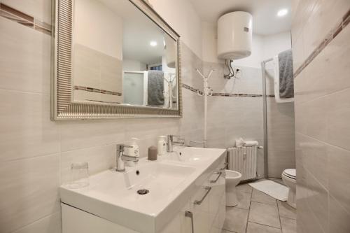 Baño blanco con lavabo y espejo en Pretty Space, en Milán