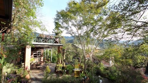 竹東鎮的住宿－老農夫山莊 ，享有树木花园和建筑的景色