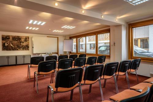 a classroom with chairs and a whiteboard in a room at Hotel Villa Siesta in Smokovce