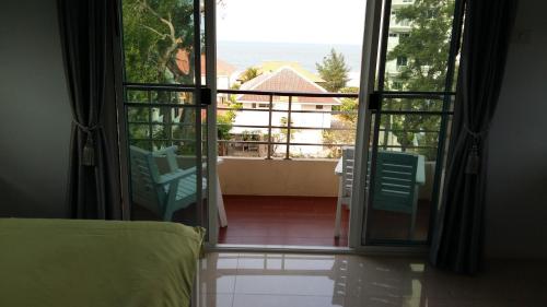 a bedroom with a view of the ocean from a balcony at Baanchomchan in Hua Hin