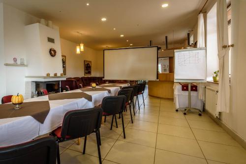 a classroom with tables and chairs and a whiteboard at Hotel Villa Siesta in Smokovce