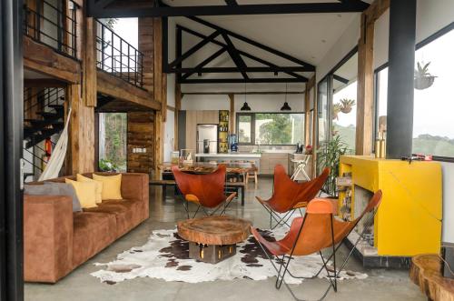 a living room with orange chairs and a couch at Casa Bambuco Filandia in Filandia
