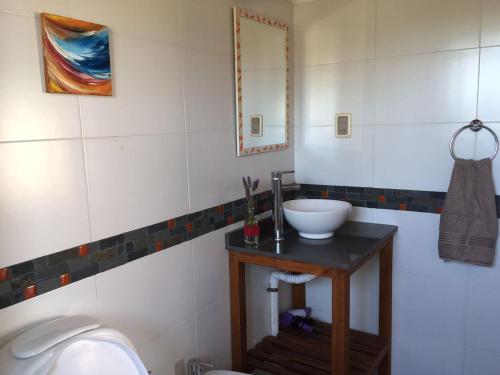 a bathroom with a sink and a toilet at Cabañas El Ocio in Punta Del Diablo