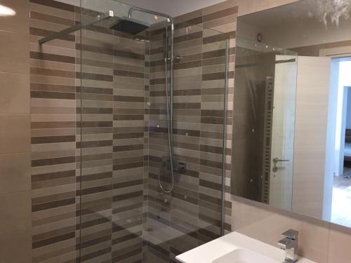 a bathroom with a shower with a sink and a mirror at Villa Carmen in Opatija