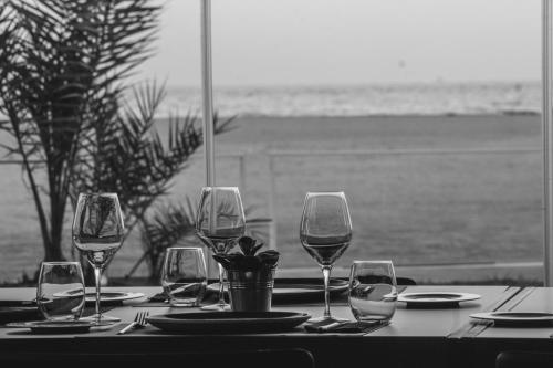 a table with wine glasses on a table at the beach at Botaniq Hotel Boutique in Mojácar