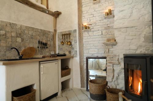a kitchen with a fireplace and a stone wall at Overture Studio in Kamianets-Podilskyi