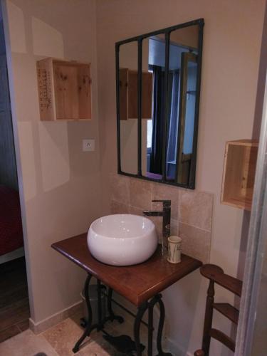 a bathroom with a sink and a mirror on a table at Le Presbytère in Les Ageux