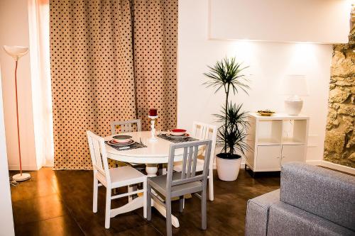 a dining room with a white table and chairs at Archinuè in Siracusa