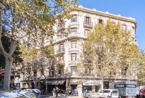 a tall white building with cars parked in front of it at Bailén Green House in Barcelona