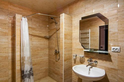 a bathroom with a sink and a shower at SPA Resort HeRICH in Bukovel