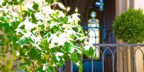 a fence in front of a church with a stained glass window at Schloss Weitenburg in Starzach
