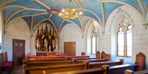 a church with wooden pews and a chandelier at Schloss Weitenburg in Starzach
