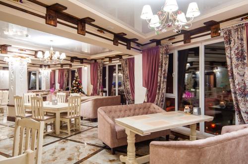 uma sala de jantar com mesas e cadeiras e um lustre em SPA Resort HeRICH em Bukovel