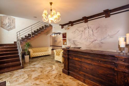 a living room with a staircase and a large wall at SPA Resort HeRICH in Bukovel