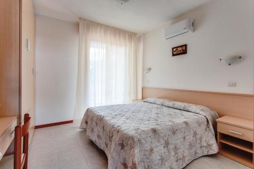 pokój hotelowy z łóżkiem i oknem w obiekcie Aparthotel Costa Paradiso w mieście Lido Adriano