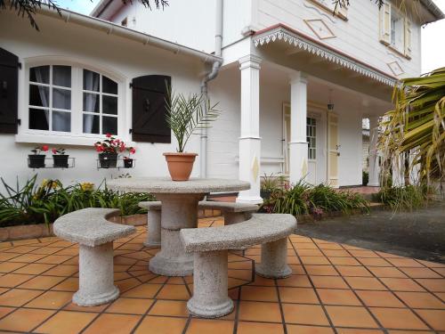 a table and two benches in front of a house at Le Cimendef in Salazie