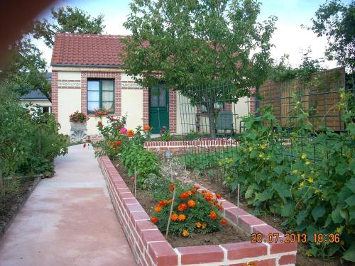 un jardín frente a una casa con flores en Le Petit Saint-Julien en Saint-Julien-les-Villas