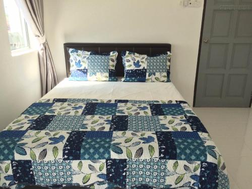 un letto con una trapunta blu e bianca sopra di Sleepee Homestay a Teluk Intan