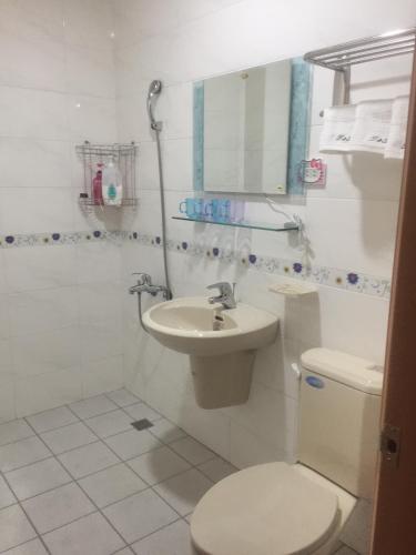 a bathroom with a toilet and a sink and a mirror at Traveler Station in Kaohsiung