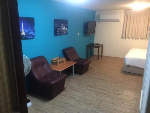 a hotel room with a bed and two chairs at Traveler Station in Kaohsiung
