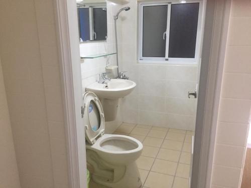 a bathroom with a toilet and a sink at Traveler Station in Kaohsiung
