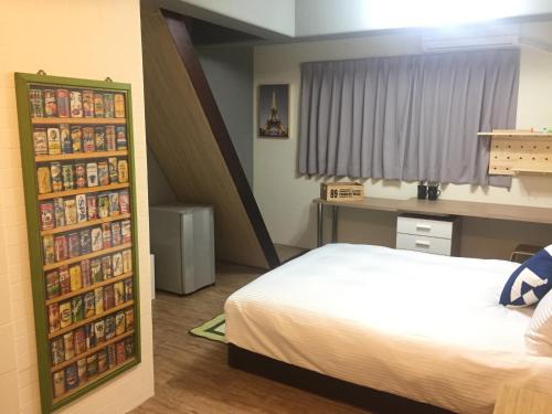 a bedroom with a bed and a book shelf filled with dvds at Traveler Station in Kaohsiung