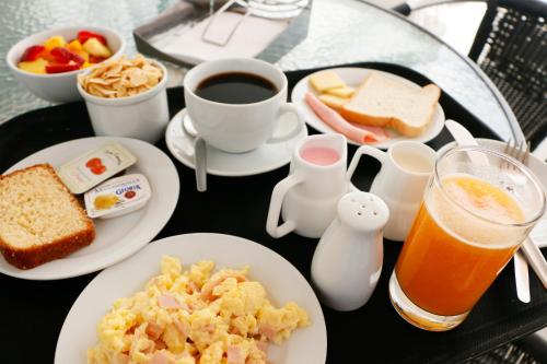 a table with plates of breakfast food and a drink at Hotel Solec in Chiclayo