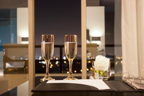 two glasses of champagne on a table with a view at Casa Andina Premium Golf Los Incas in Lima