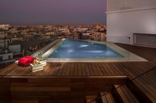 a large swimming pool on the roof of a building at Hotel Colón Gran Meliá - The Leading Hotels of the World in Seville