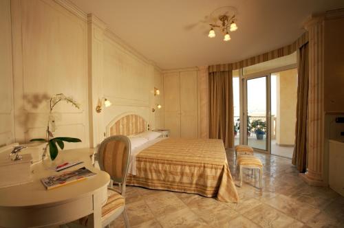 Hotel Boracay في ألبا أدرياتيكا: غرفة نوم بسرير ومكتب ومغسلة
