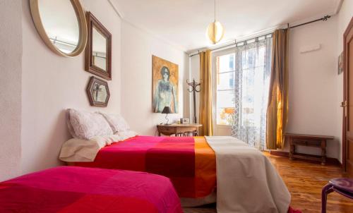 ログローニョにあるPiso con encanto en zona de tapasのベッドルーム(カラフルなベッド1台、鏡付)