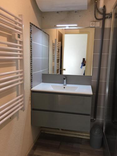 a bathroom with a sink and a mirror at Appartement Superbagnères in Superbagnères