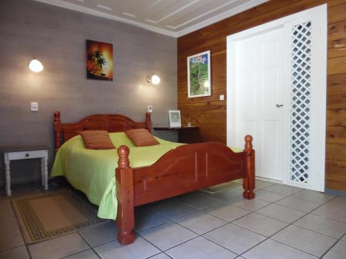 een slaapkamer met een bed met een groen dekbed bij Le Cimendef in Salazie