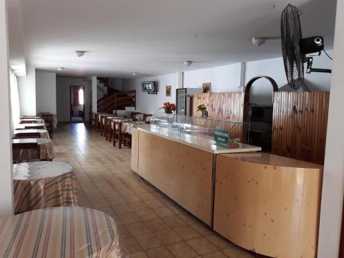 ein Restaurant mit einer Theke mit Tischen und Stühlen in der Unterkunft Hotel La Maison in La Lucila del Mar