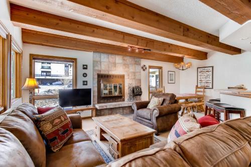 a living room with leather furniture and a fireplace at The Plaza Condominiums by Crested Butte Mountain Resort in Mount Crested Butte