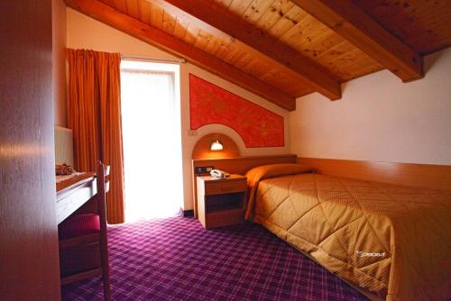een hotelkamer met een bed en een raam bij Hotel Ristorante Milano in Vermiglio