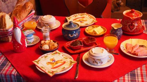 un tavolo con una tovaglia rossa con cibo e bevande di Chambres d'Hôtes Chez Mado Ottrott a Ottrott