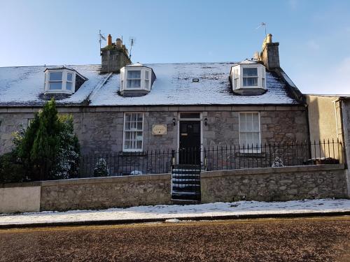 an old stone house with two windows and a door at Atticus Central Guest House in Aberdeen