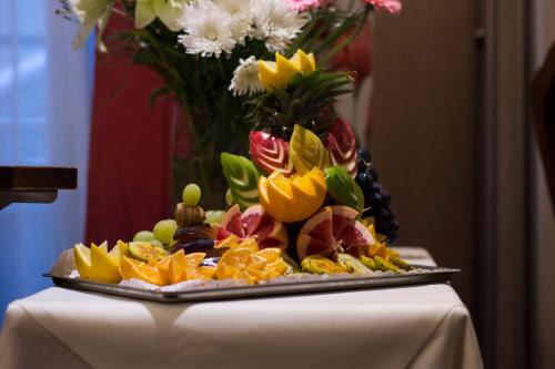 een fruitschaal op een tafel met een vaas met bloemen bij Hostellerie Saint Florent in Oberhaslach