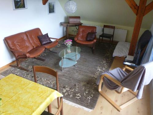 ein Wohnzimmer mit Ledermöbeln und einem Tisch in der Unterkunft Ferienwohnung Schorfheide in Joachimsthal