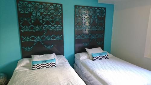 two beds in a room with blue walls at Miami Sun Hotel - Downtown/Port of Miami in Miami