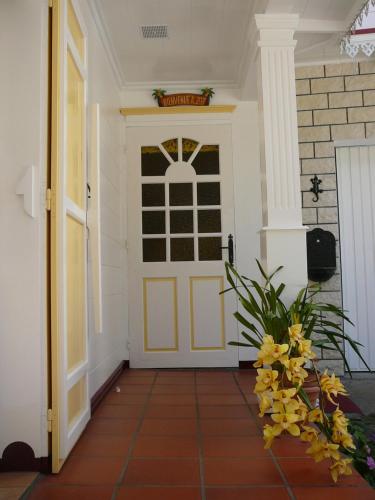 a front door of a house with yellow flowers at Le Cimendef in Salazie