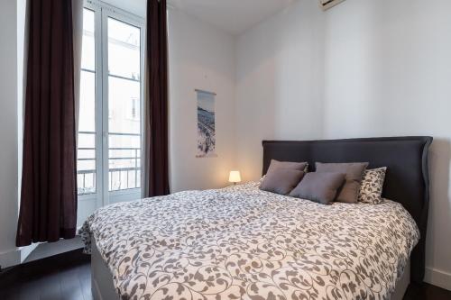 une chambre avec un lit avec une grande fenêtre dans l'établissement Prestige Apartment, near the beaches, à Nice