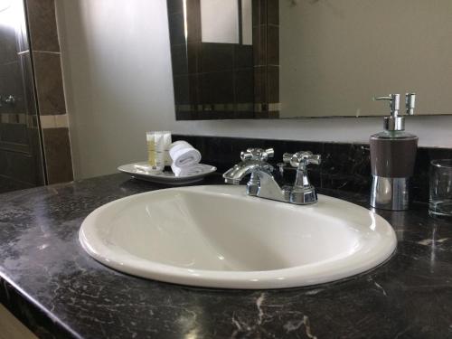a white sink in a bathroom with a mirror at Hotel Boutique Villa Casuarinas in Cali