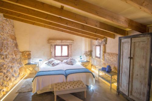 een slaapkamer met een groot bed in een gebouw bij Agroturismo Petit Hotel Son Perdiu - Adults Only in Sa Ràpita