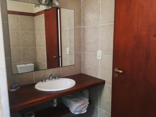 a bathroom with a sink and a mirror at Apart Lawn Tennis Pinamar in Pinamar