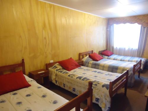 a room with three beds and a window at HOTEL CASAGRANDE con estacionamiento EXCLUSIVO in Valdivia